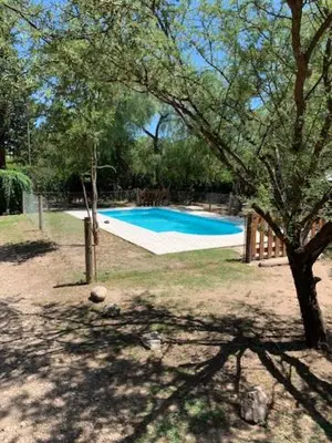 a swimming pool in a yard with a tree at Arcángeles del Oeste - Descanso al pie de la montaña in La Población