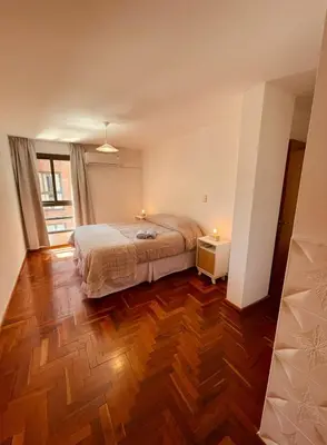 a bedroom with a bed and a wooden floor at LitStay - Departamento con Cochera Barrio General Paz in Cordoba
