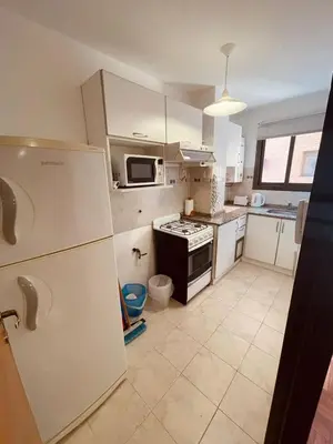 a kitchen with a refrigerator and a stove top oven at LitStay - Departamento con Cochera Barrio General Paz in Cordoba