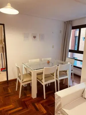 a dining room with a white table and chairs at LitStay - Departamento con Cochera Barrio General Paz in Cordoba