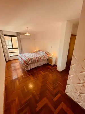a bedroom with a bed and a wooden floor at LitStay - Departamento con Cochera Barrio General Paz in Cordoba