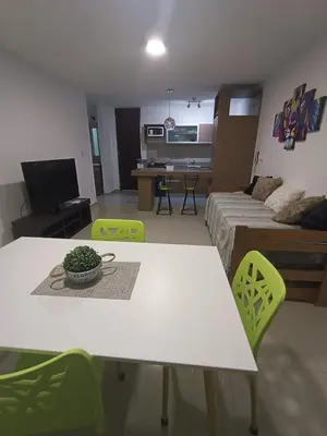 a living room with a white table and green chairs at Departamento centrico Carlos Paz in Villa Carlos Paz