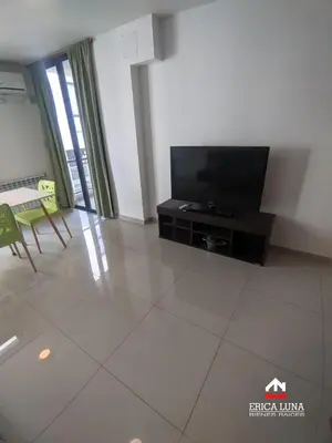 a living room with a television and a table at Departamento centrico Carlos Paz in Villa Carlos Paz