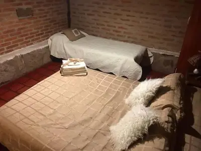 two beds sitting next to each other in a room at Pachamama cabañas en la montaña in Mina Clavero