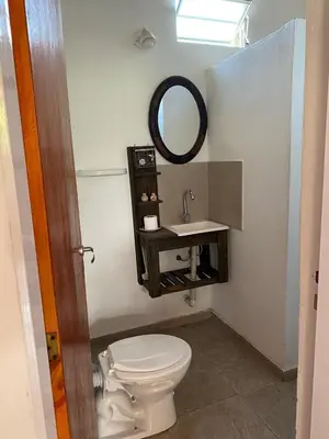 a bathroom with a toilet and a sink and a mirror at Pachamama cabañas en la montaña in Mina Clavero