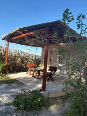 a picnic shelter with a picnic table in front of a house at Pachamama cabañas en la montaña in Mina Clavero