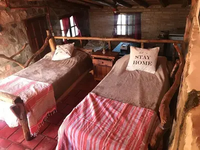 a bedroom with two beds and a sign that says stay home at Pachamama cabañas en la montaña in Mina Clavero
