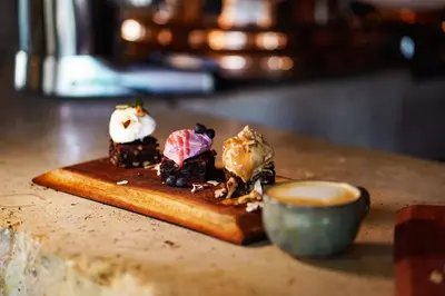 a plate with three desserts and a cup of coffee at Terra Firma Hotel Boutique in Villa Carlos Paz