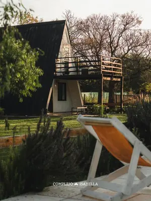 a house with a deck on the side of it at COMPLEJO ISABELLA in Villa Amancay