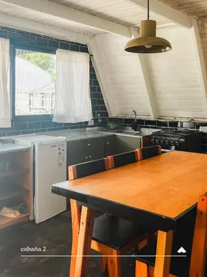 a kitchen with a wooden table in a kitchen at COMPLEJO ISABELLA in Villa Amancay