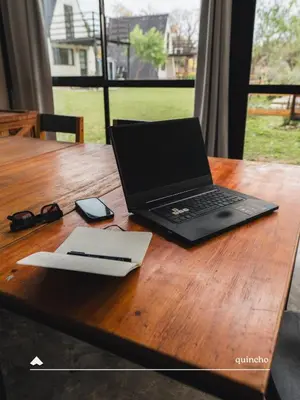 a laptop computer sitting on top of a wooden table at COMPLEJO ISABELLA in Villa Amancay