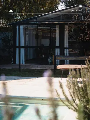a table and a bench in front of a building at COMPLEJO ISABELLA in Villa Amancay