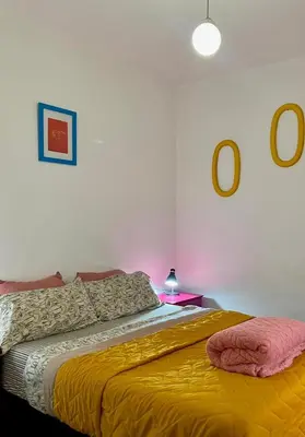 a bedroom with a bed with a yellow blanket at Plazoleta Apartamento in Cordoba