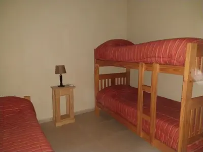 a bedroom with two bunk beds and a lamp at ALA DE LIBERTAD in Villa Yacanto