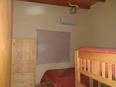 a bedroom with a bed and a dresser and a window at ALA DE LIBERTAD in Villa Yacanto