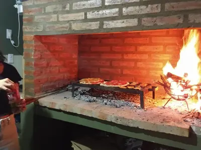 a brick oven with some pizzas cooking in it at ALA DE LIBERTAD in Villa Yacanto