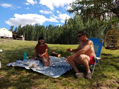 a man and a woman sitting on a picnic blanket at ALA DE LIBERTAD in Villa Yacanto