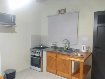a kitchen with a sink and a stove at ALA DE LIBERTAD in Villa Yacanto