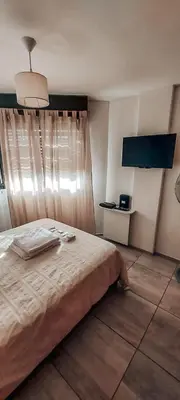 a bedroom with a large bed and a window at Departamento céntrico LA CAÑADA con BALCÓN a metros de la PEATONAL de la ciudad in Cordoba