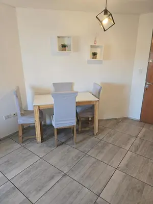 a dining room with a wooden table and chairs at Departamento céntrico LA CAÑADA con BALCÓN a metros de la PEATONAL de la ciudad in Cordoba