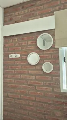 a brick wall with three white plates on it at Casa Del Valle Traslasierra in Las Chacras (La Paz)