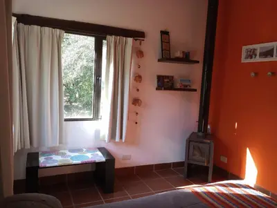 a living room with a stove and a window at Casa Del Valle Traslasierra in Las Chacras (La Paz)