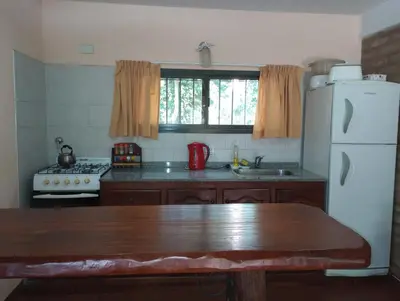 a kitchen with a white refrigerator and a sink at Casa Del Valle Traslasierra in Las Chacras (La Paz)