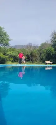 a man and a woman standing in a large pool of water at Casa Del Valle Traslasierra in Las Chacras (La Paz)