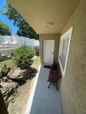 a porch with a bench next to a door at Brisas del Sur in Villa Carlos Paz