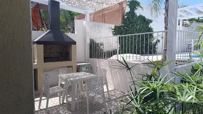 a patio with a table and chairs and a stove at Brisas del Sur in Villa Carlos Paz
