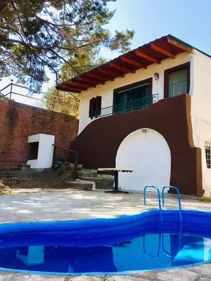a house with a swimming pool in front of a house at Casa Calo Bialet Massé in Bialet Massé