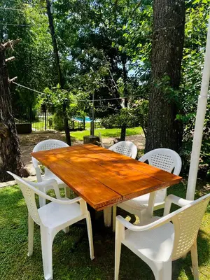 a wooden table and white chairs around a tree at Casa Calo Bialet Massé in Bialet Massé