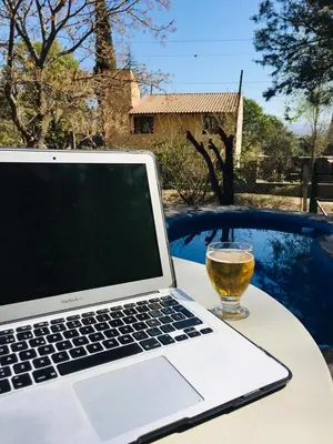 a laptop computer sitting on a table with a glass of wine at Casa Calo Bialet Massé in Bialet Massé