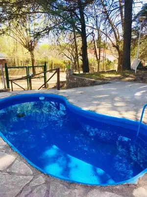 a blue pool with a hose in a yard at Casa Calo Bialet Massé in Bialet Massé