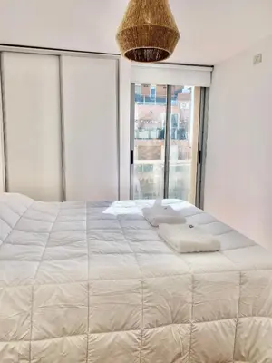 a bedroom with a large white bed with a large window at Ayres de Córdoba 2, Asador, Terraza, Balcón, Excelente Ubicación in Cordoba