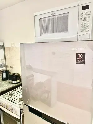 a microwave above a stove in a kitchen at Ayres de Córdoba 2, Asador, Terraza, Balcón, Excelente Ubicación in Cordoba