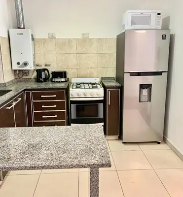 a kitchen with a stove and a refrigerator at Ayres de Córdoba 2, Asador, Terraza, Balcón, Excelente Ubicación in Cordoba