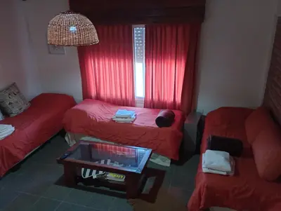 a room with two beds and a table and a window at Cabañas del Cerro Mirador in Villa Rumipal