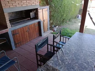 a patio with a table and chairs and a grill at Cabañas del Cerro Mirador in Villa Rumipal
