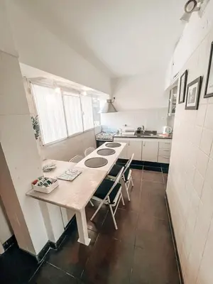 a kitchen with a wooden table and chairs in it at Departamento zona CENTRO BOLIVAR y LA CAÑADA con BALCÓN in Cordoba