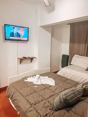 a bedroom with a bed and a tv on the wall at Departamento zona CENTRO BOLIVAR y LA CAÑADA con BALCÓN in Cordoba
