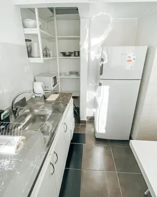 a kitchen with a sink and a refrigerator at Departamento zona CENTRO BOLIVAR y LA CAÑADA con BALCÓN in Cordoba