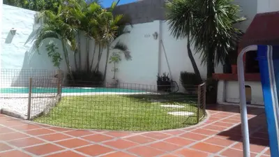 a fence around a swimming pool with palm trees at un lindo departamento in Cordoba