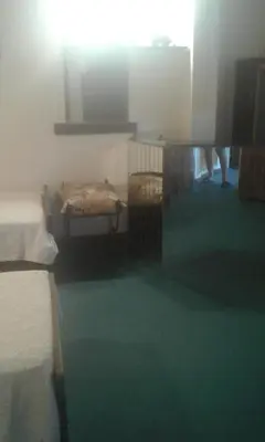 a room with two beds and a green floor at un lindo departamento in Cordoba