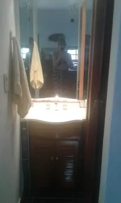 a person taking a picture of a bathroom mirror at un lindo departamento in Cordoba