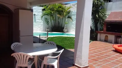 a patio with a white table and chairs and a pool at un lindo departamento in Cordoba