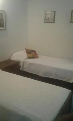 two twin beds in a bedroom with a pillow at un lindo departamento in Cordoba