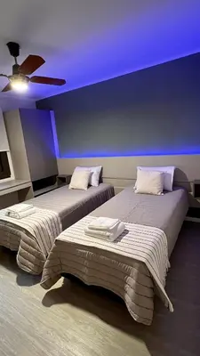 two beds in a room with a purple ceiling at Verona in Cordoba