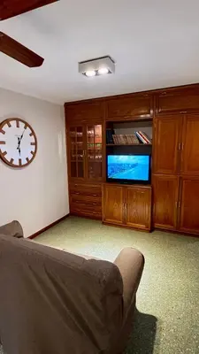 a living room with a couch and a clock on the wall at Verona in Cordoba