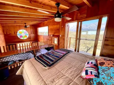 a bedroom with a large bed in a cabin at Mandala Tiny House, Traslasierra. in Yacanto